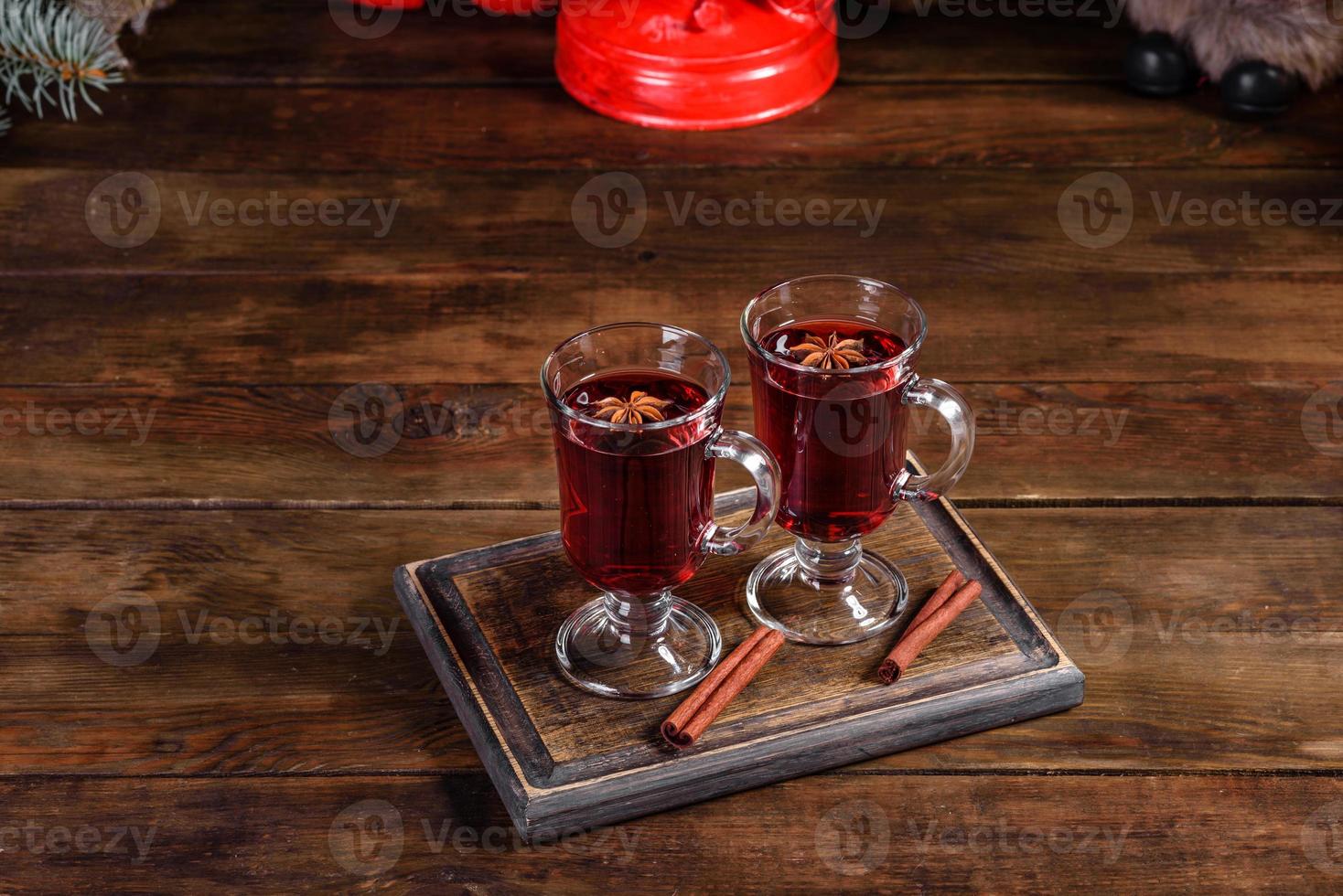 Natal quente com vinho tinto com especiarias e frutas em uma mesa escura. foto