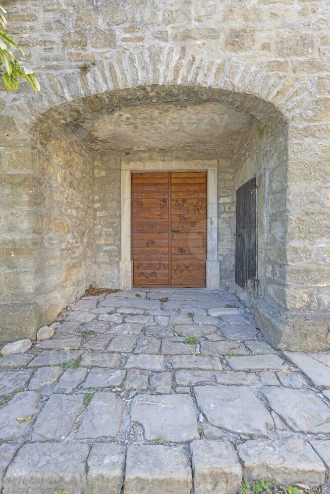 imagem do uma castanho-avermelhado Entrada porta para uma residencial construção com a Antiguidade fachada foto