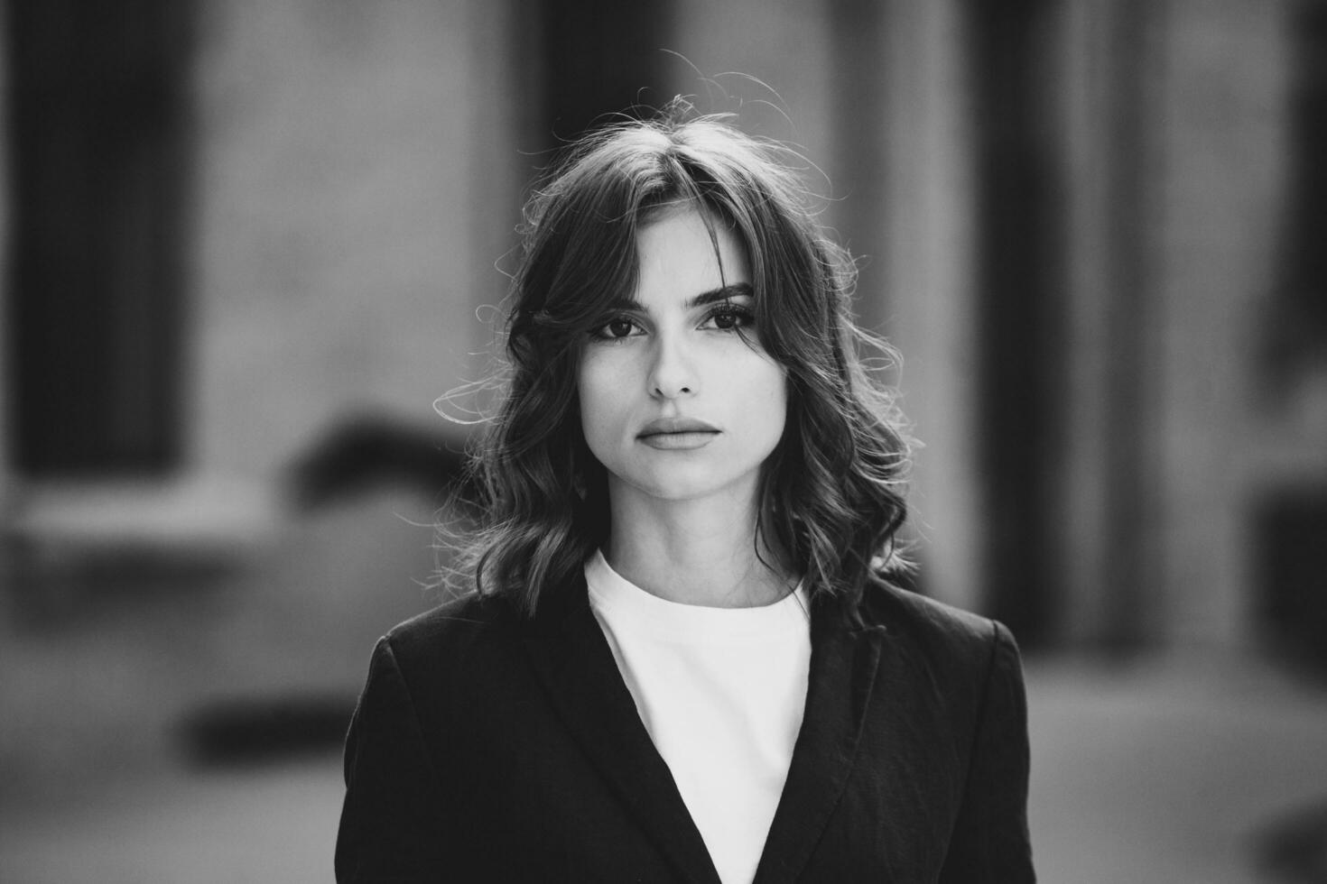 retrato do uma bem sucedido o negócio mulher dentro frente do moderno o negócio prédio. jovem Gerente poses fora. mulher empregado do a escritório. foto