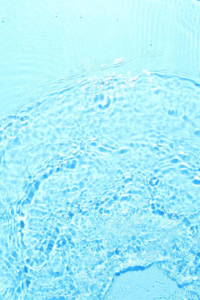 textura de espirrar água limpa no fundo azul foto