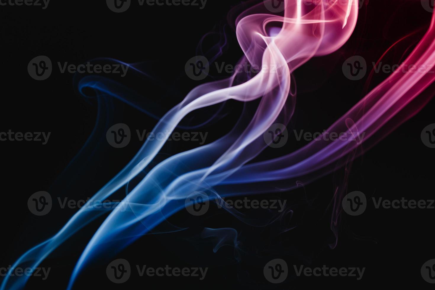 fumaça colorida flutuando em fundo escuro foto