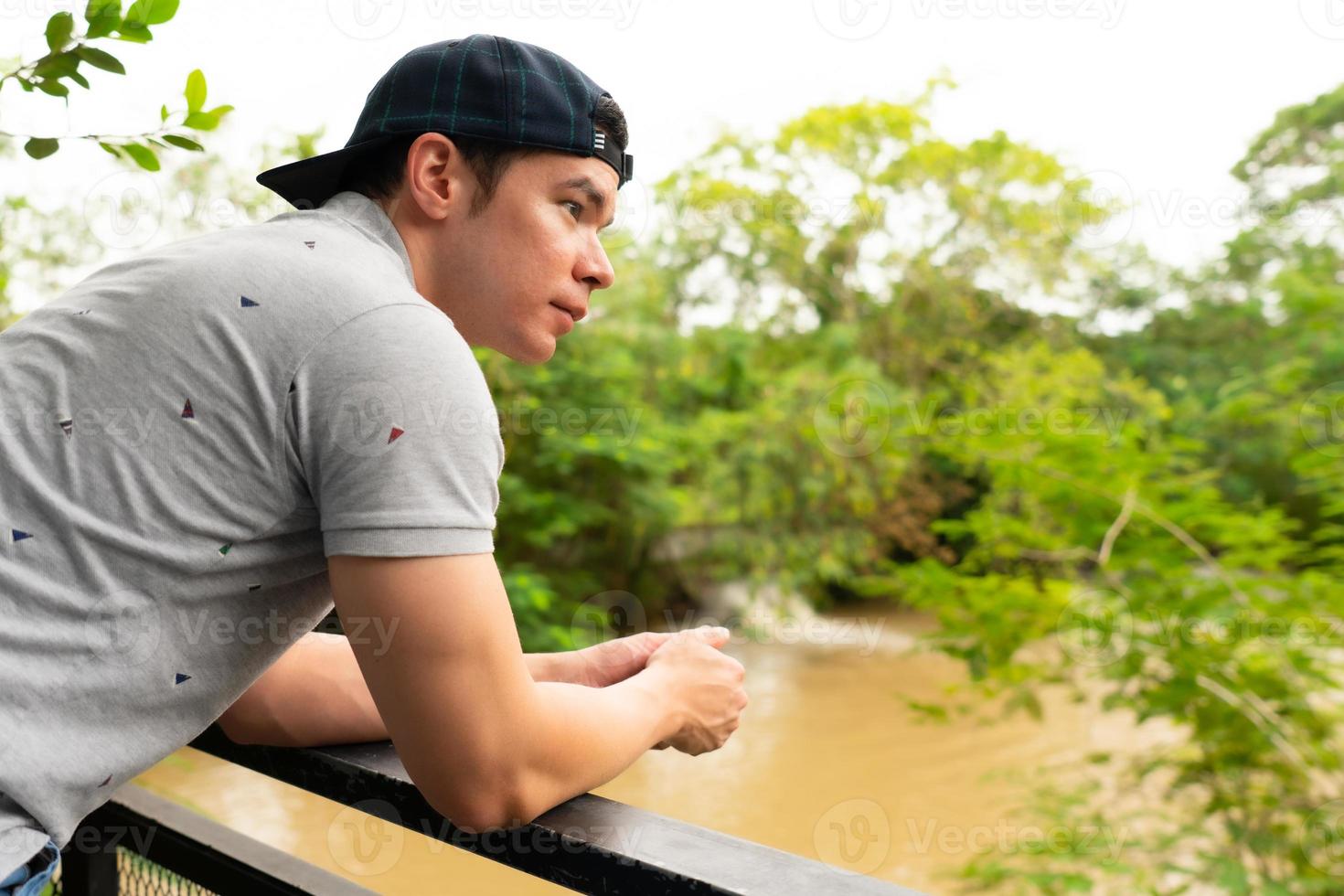 jovem homem caucasiano viajar para o rio na floresta foto