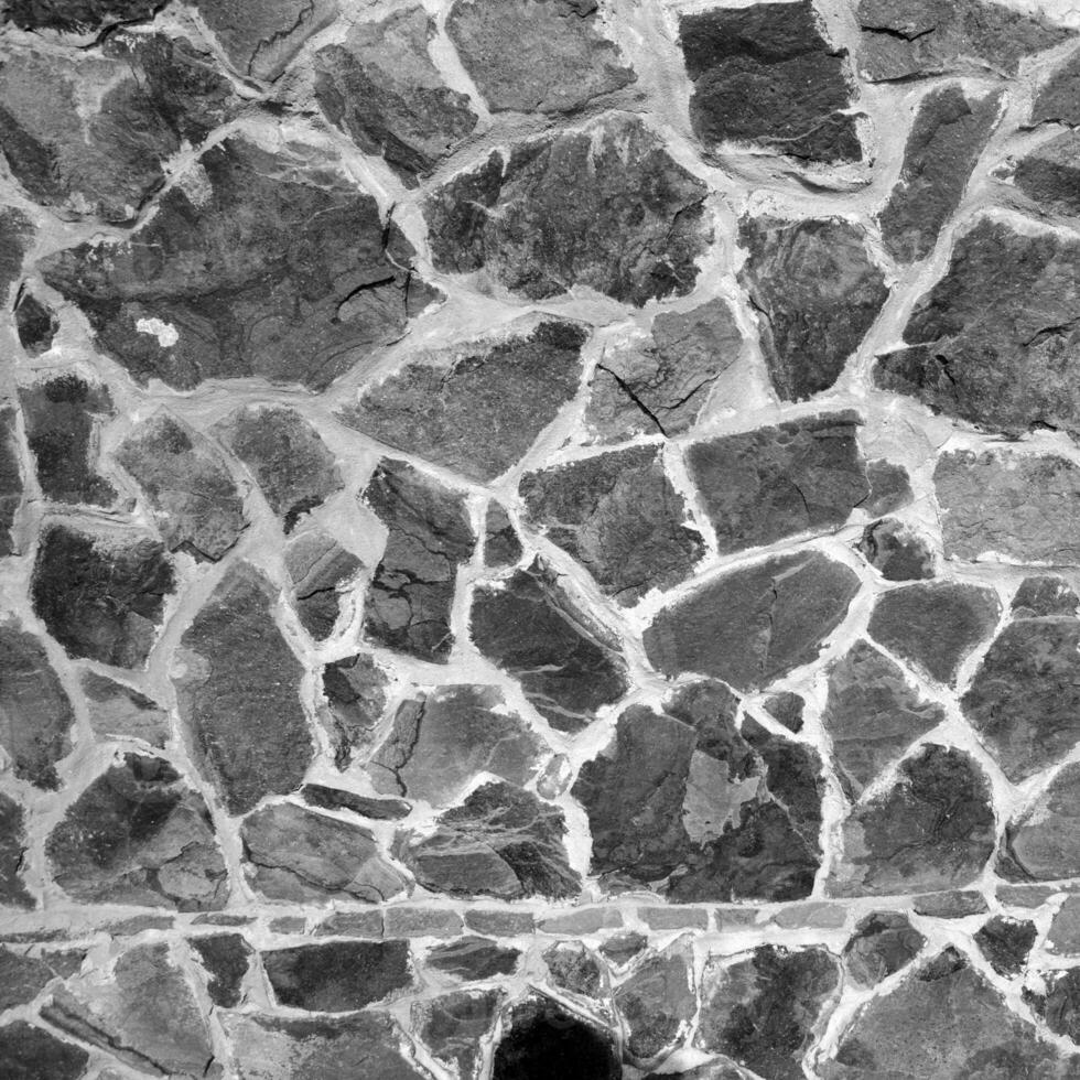 desatado pedra padronizar. velho pedra parede Preto e branco monocromático textura foto
