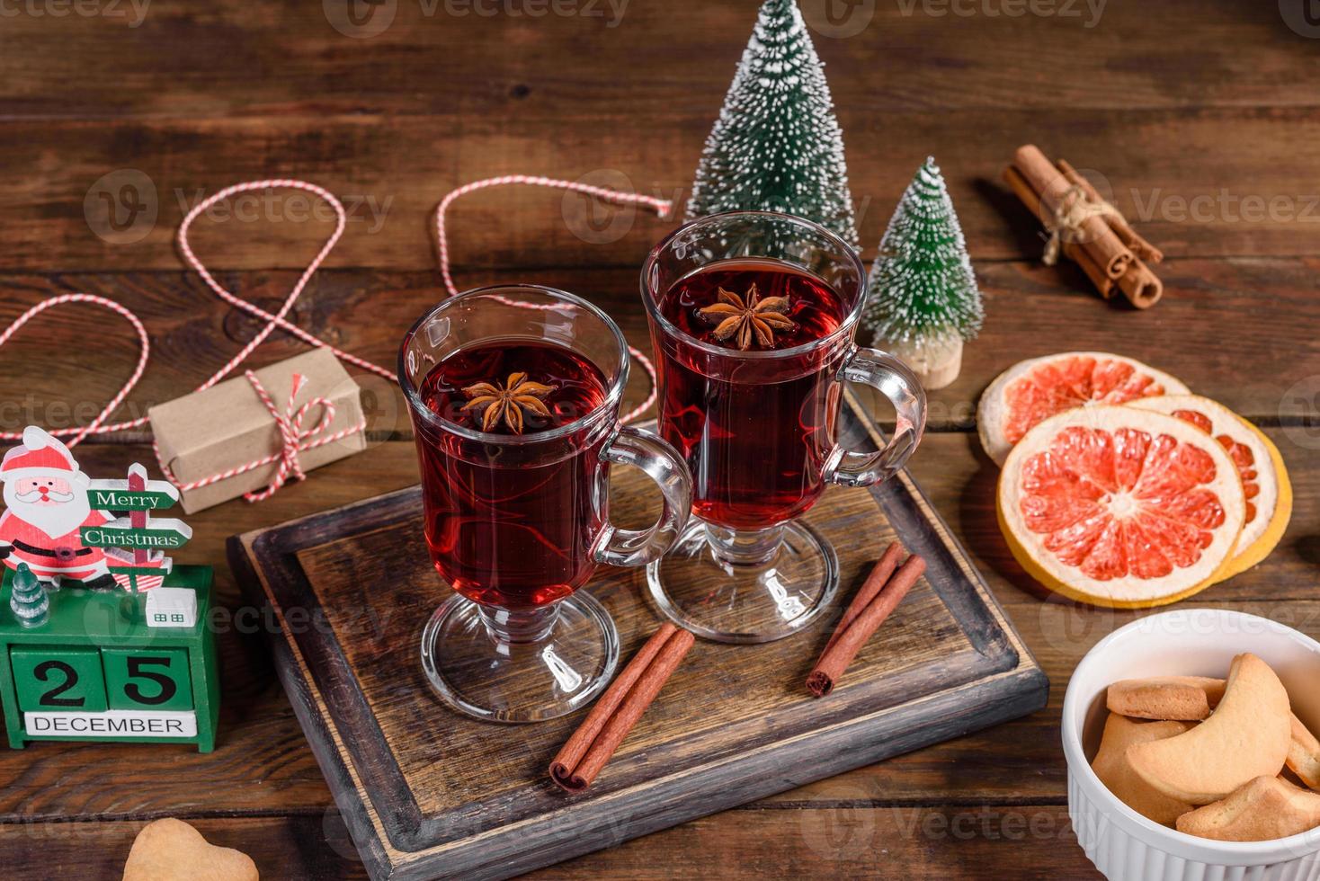 Natal quente com vinho tinto com especiarias e frutas em uma mesa escura. foto