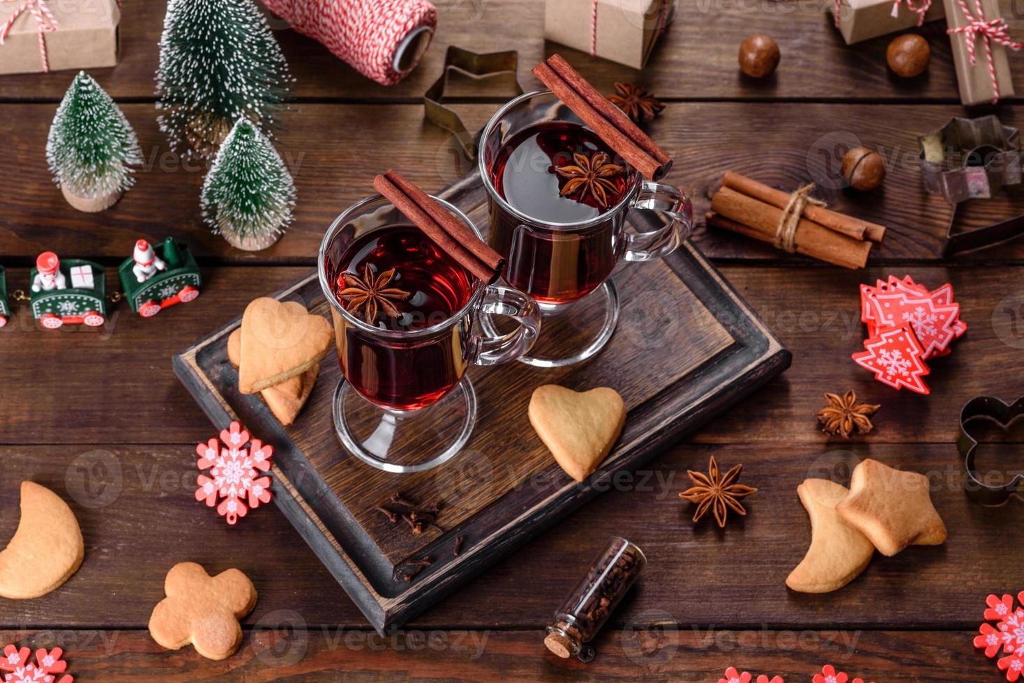 Natal quente com vinho tinto com especiarias e frutas em uma mesa escura. foto