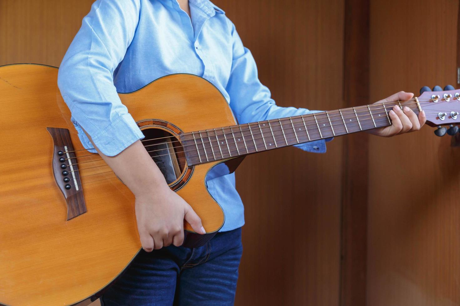 menino tocando violão clássico se divertindo foto