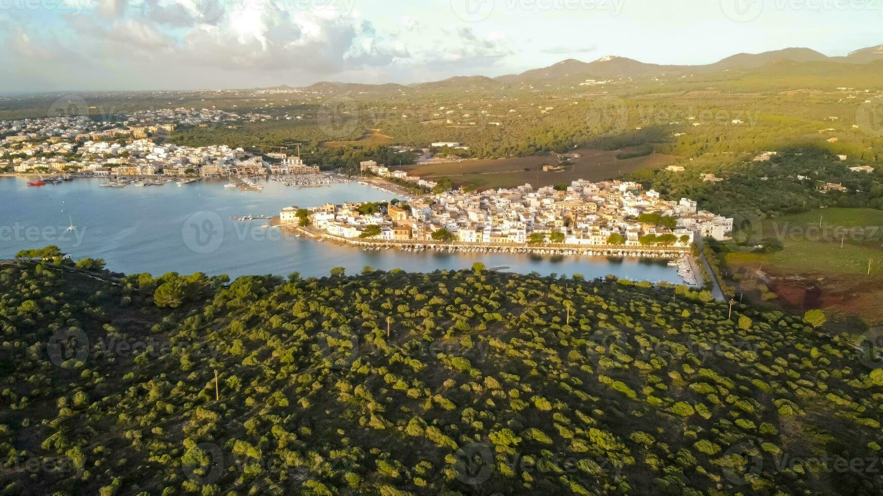 zangão aéreo Visão do a Mediterrâneo mar às nascer do sol do pequeno pescaria porta e marina, dentro portocolom, maiorca, baleares ilhas foto