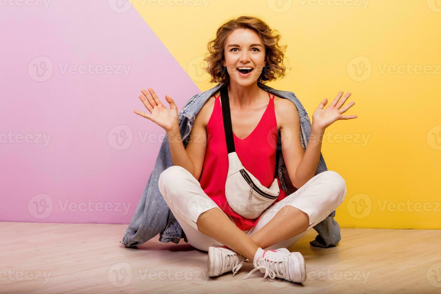 engraçado mulher com curto ondulado cabelos dançando e tendo Diversão em multicolorido fundo. cópia de espaço para texto. foto