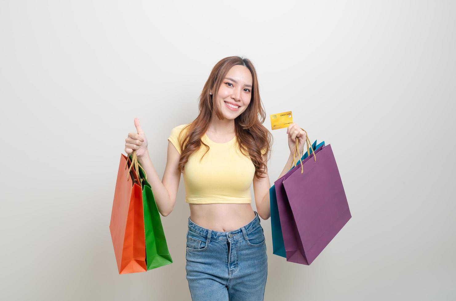 retrato de uma mulher bonita segurando uma sacola de compras e um cartão de crédito foto