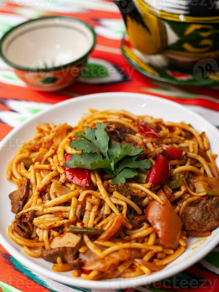 a oriental Lagman prato é caseiro Macarrão frito com carne, legumes e ervas. Oriental cozinha foto