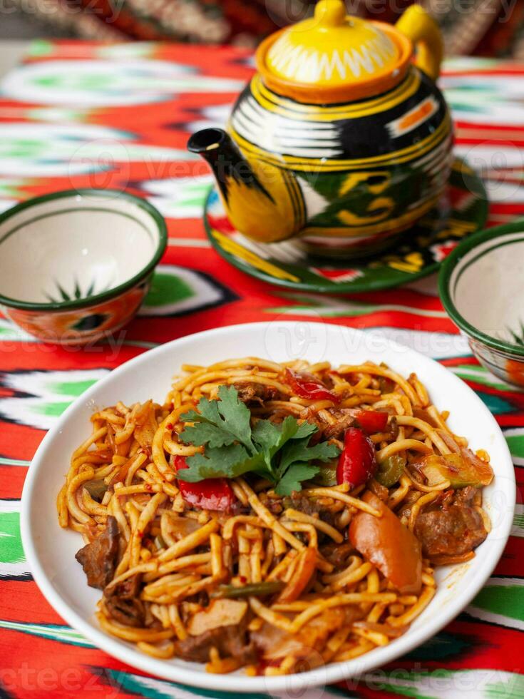 a oriental Lagman prato é caseiro Macarrão frito com carne, legumes e ervas. Oriental cozinha foto