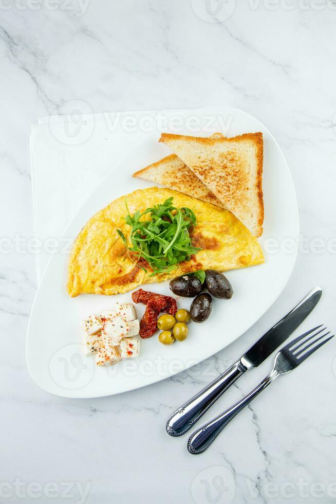 café da manhã do ovos com carne, ervas e gotas do molho com pão dentro uma volta prato topo Visão foto