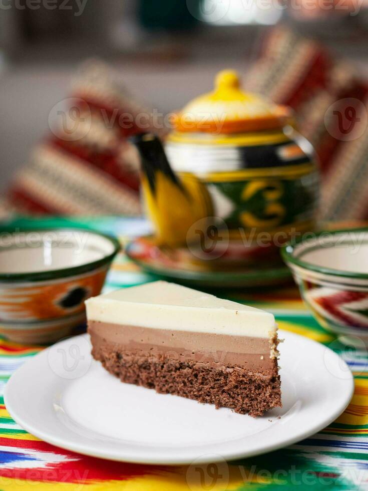 sobremesa bolo de queijo três chocolates dentro a oriental estilo com uma chaleira e uma copo para chá. foto
