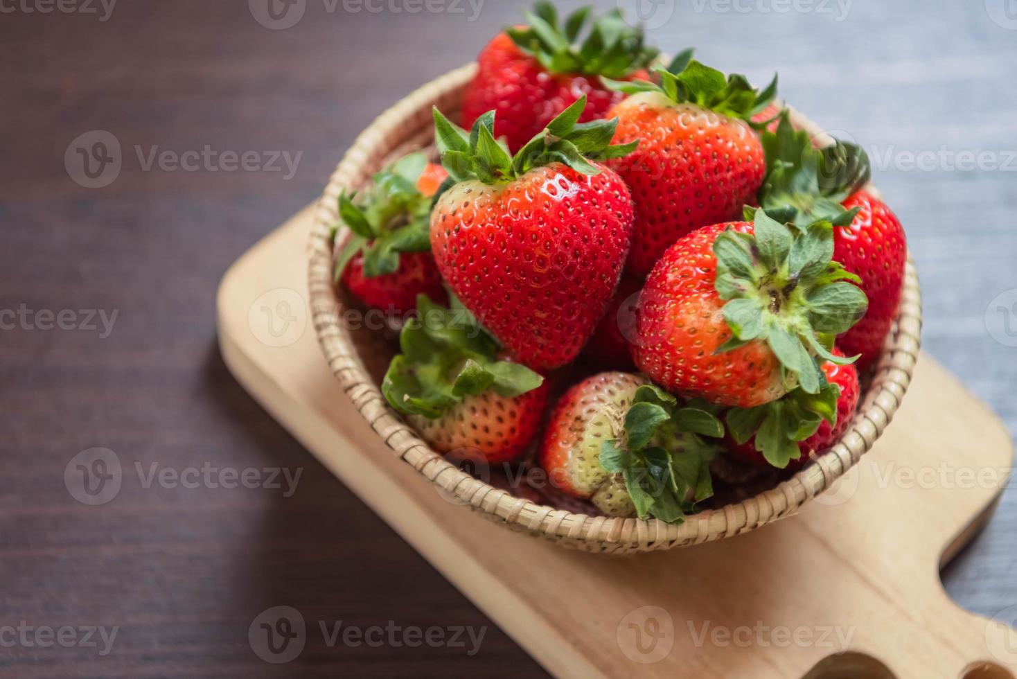 morango na cesta na mesa de madeira. frutas e vegetais foto