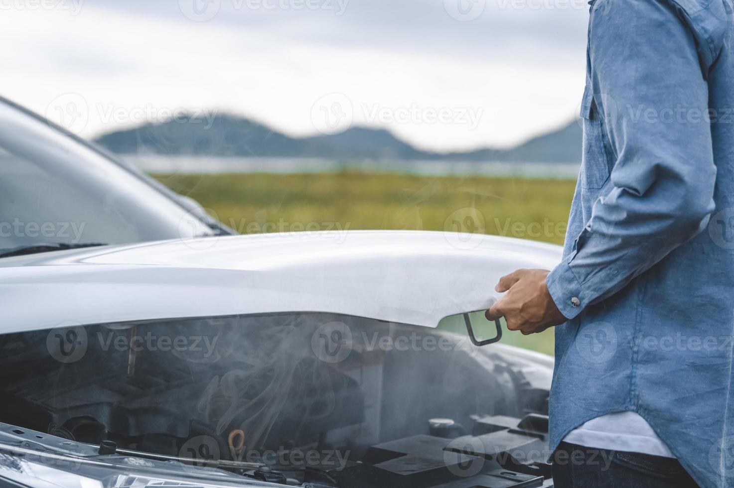 homem asiático abre o capô do carro para conserto como serviço de manutenção foto