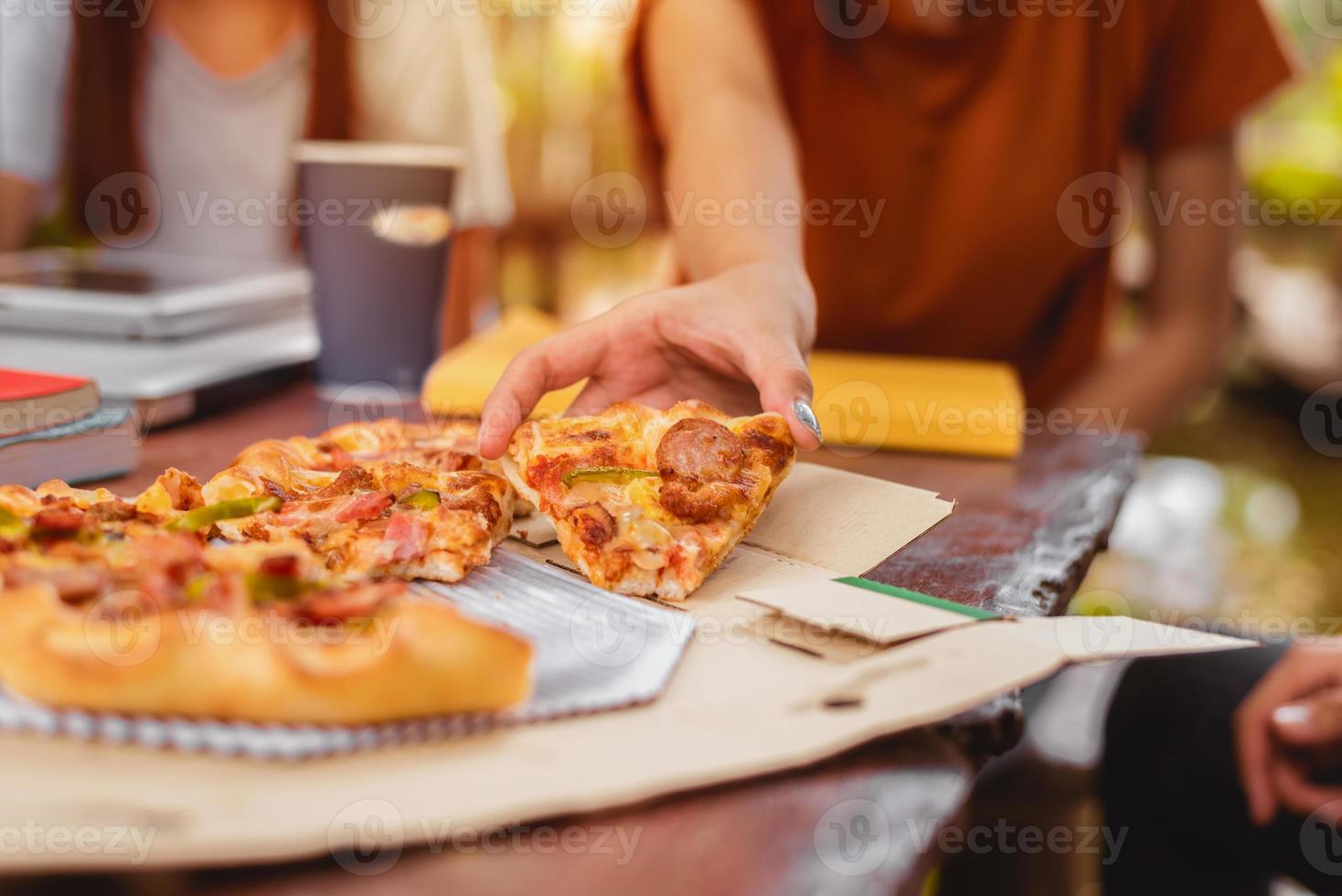 pessoas comemorando com pizza na mão foto