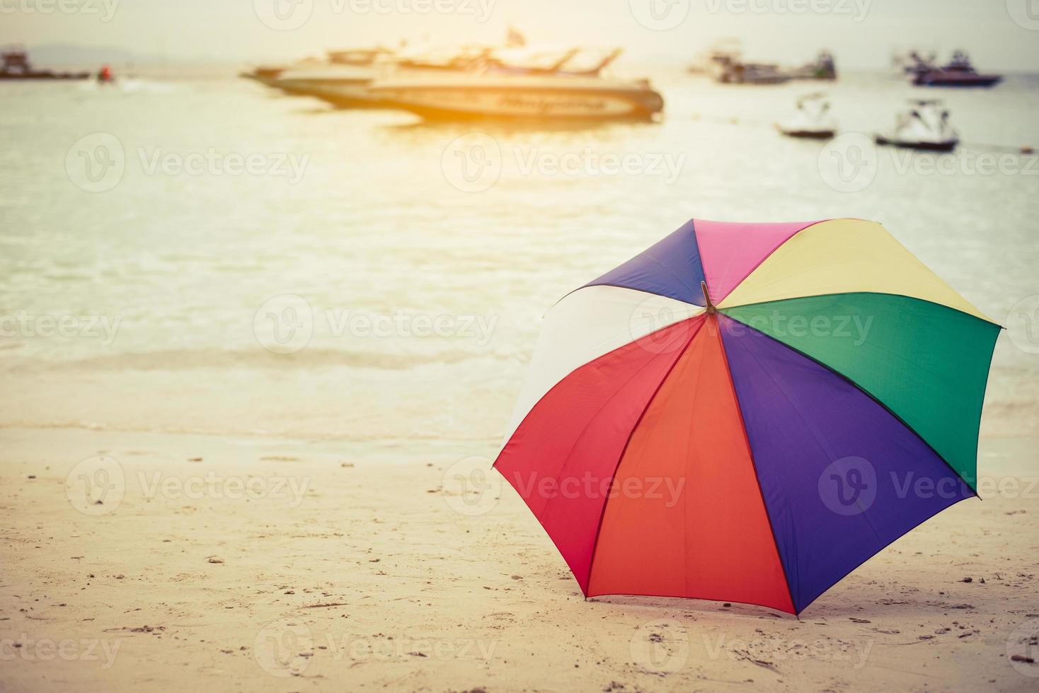 guarda-chuva colorido do arco-íris na praia foto