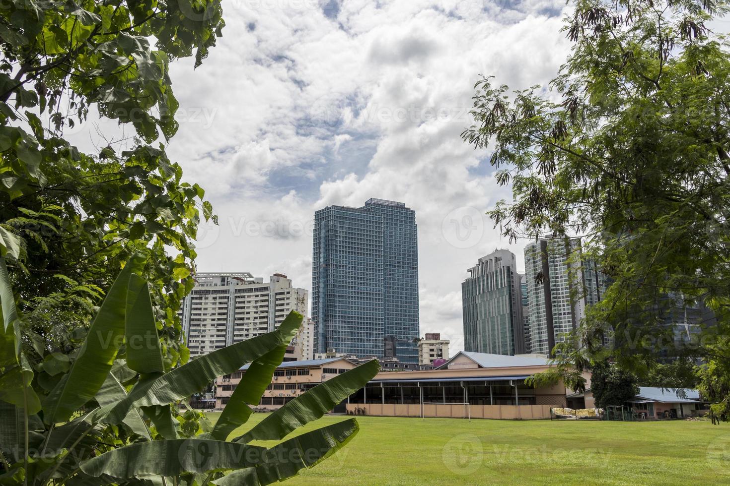 enormes arranha-céus atrás da natureza tropical, kuala lumpur. foto