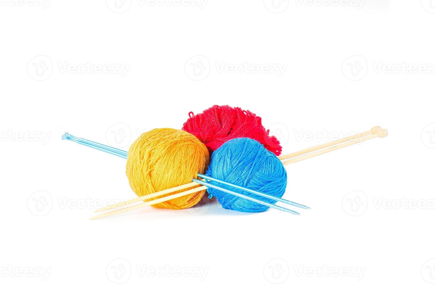 três bolas de lã espetadas por agulhas de tricô. foto