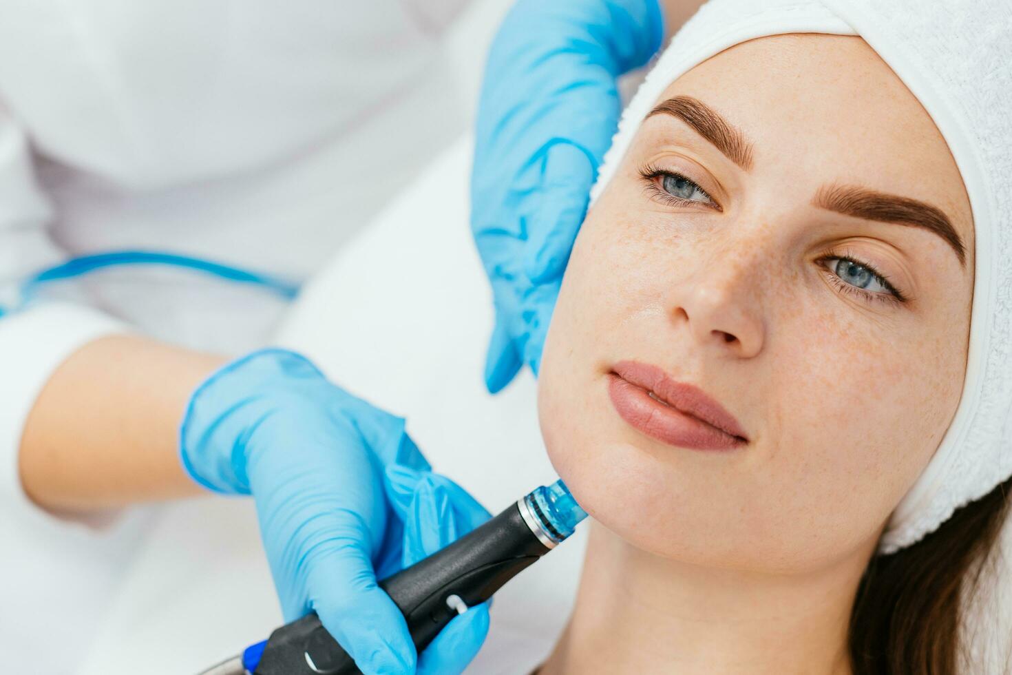 profissional fêmea cosmetologista fazendo hidra-facial procedimento dentro cosmetologia clínica. médico usando hidra vácuo limpador. rejuvenescimento e cosmetologia conceito foto