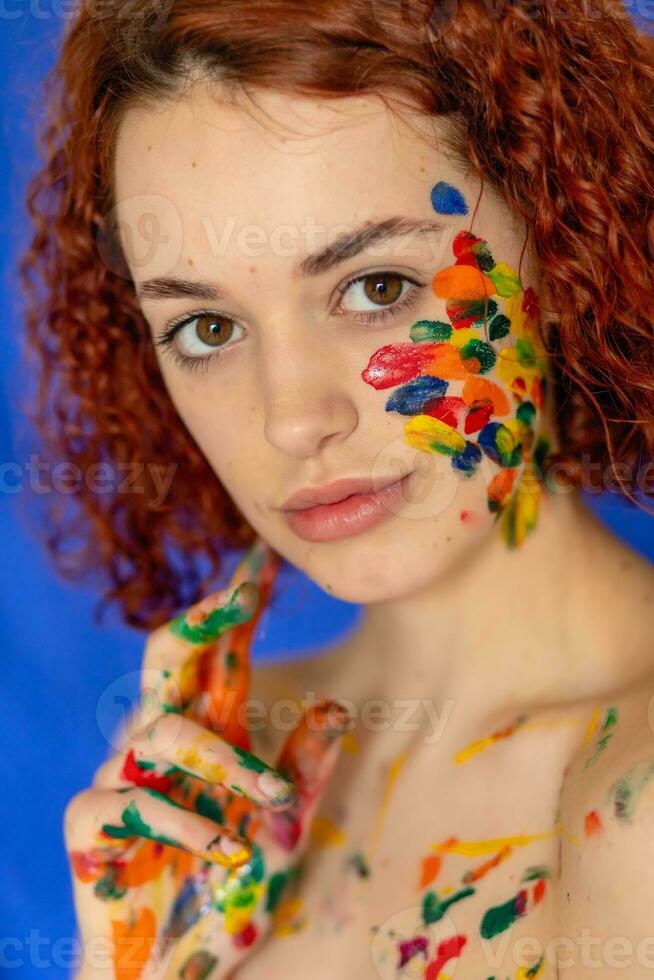 fechar-se retrato do vermelho encaracolado cabelos mulher jovem alegre sujo dentro pintar. foto