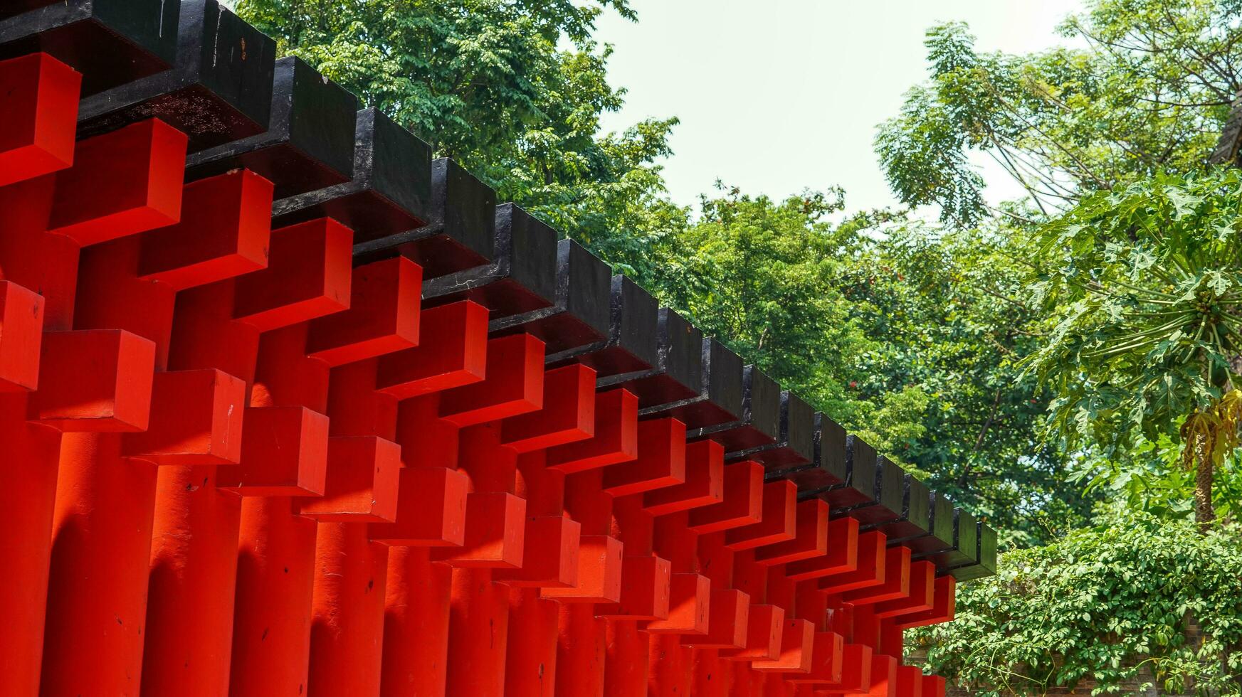 enfeites em a sam cocô kong pagode dentro semarangue, uma construção forrado com vermelho pilares e Preto linhas intercalado com reflexões do luz solar.não pessoas foto