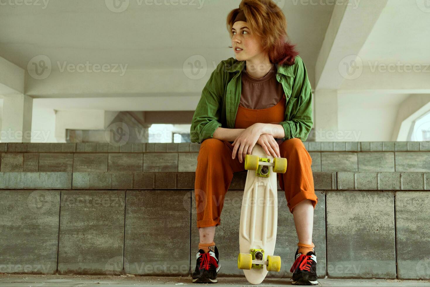 skatista menina sentado com plástico skate foto