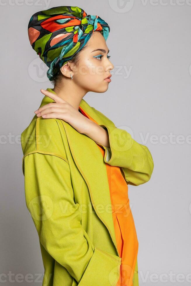 retrato do uma jovem mulher com brilhante Maquiagem e uma elegante lenço de cabeça. foto