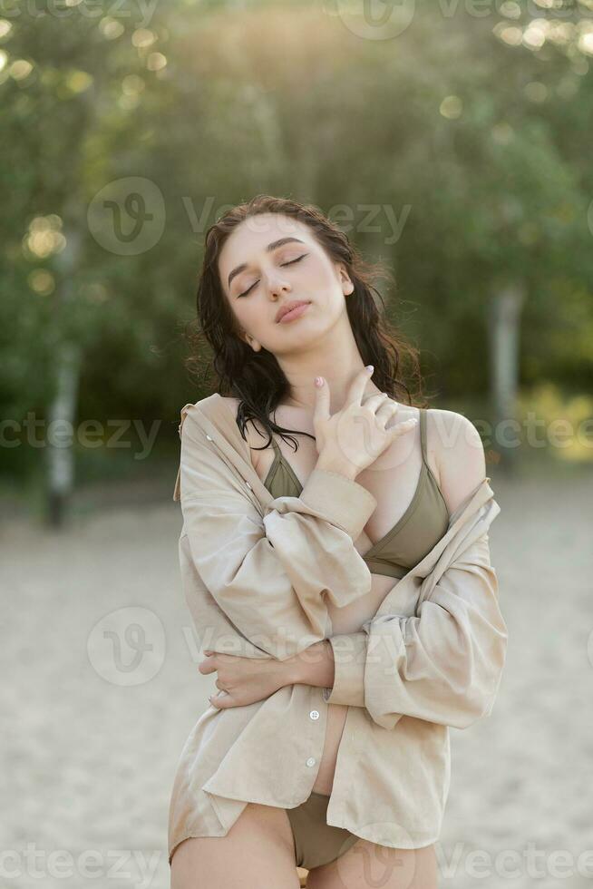 lindo boêmio estilizado e bronzeada menina às a de praia foto