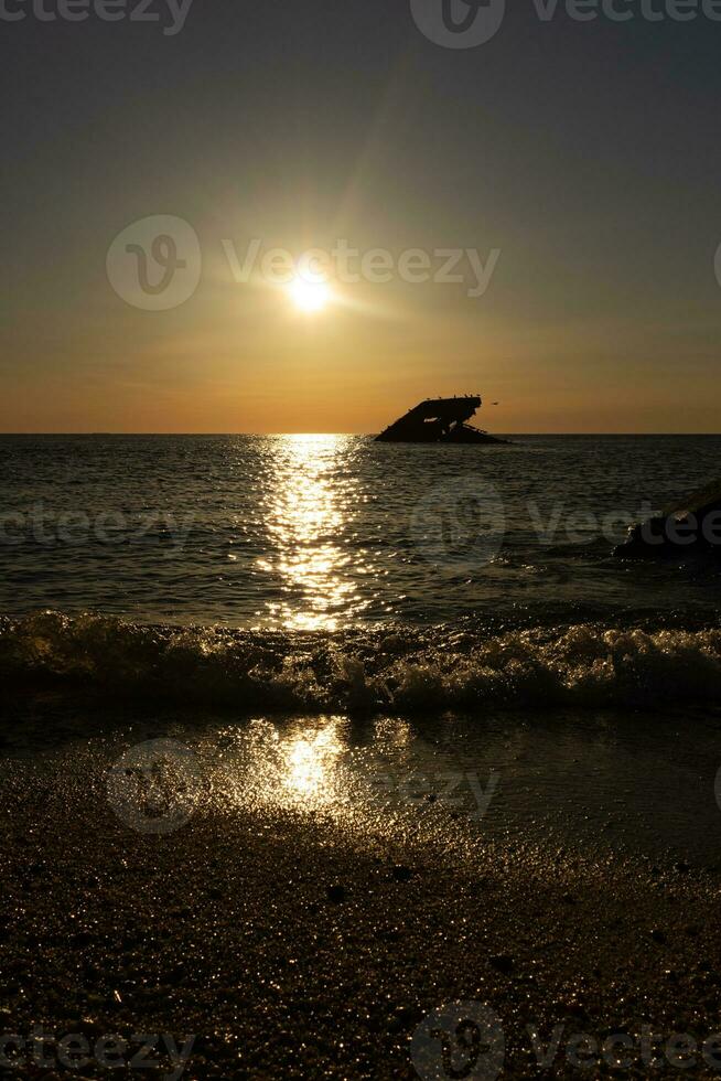 pôr do sol de praia dentro capa pode Novo jérsei Onde você pode pegue uma ótimo Visão do a Sol indo baixa através a oceano e a baía. a reflexão do a Sol em a água com a afundado navio parece tão lindo. foto