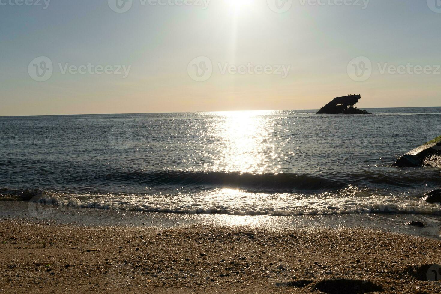 pôr do sol de praia dentro capa pode Novo jérsei Onde você pode pegue uma ótimo Visão do a Sol indo baixa através a oceano e a baía. a reflexão do a Sol em a água com a afundado navio parece tão lindo. foto