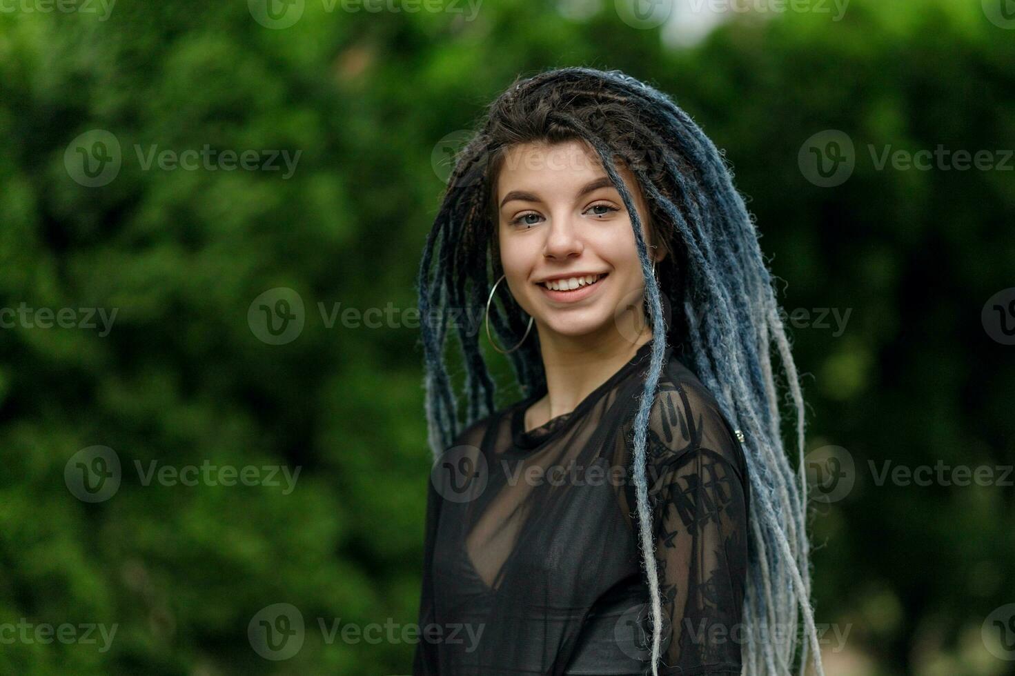 alegre caucasiano menina olhando às a Câmera e sorridente modelo com tranças foto