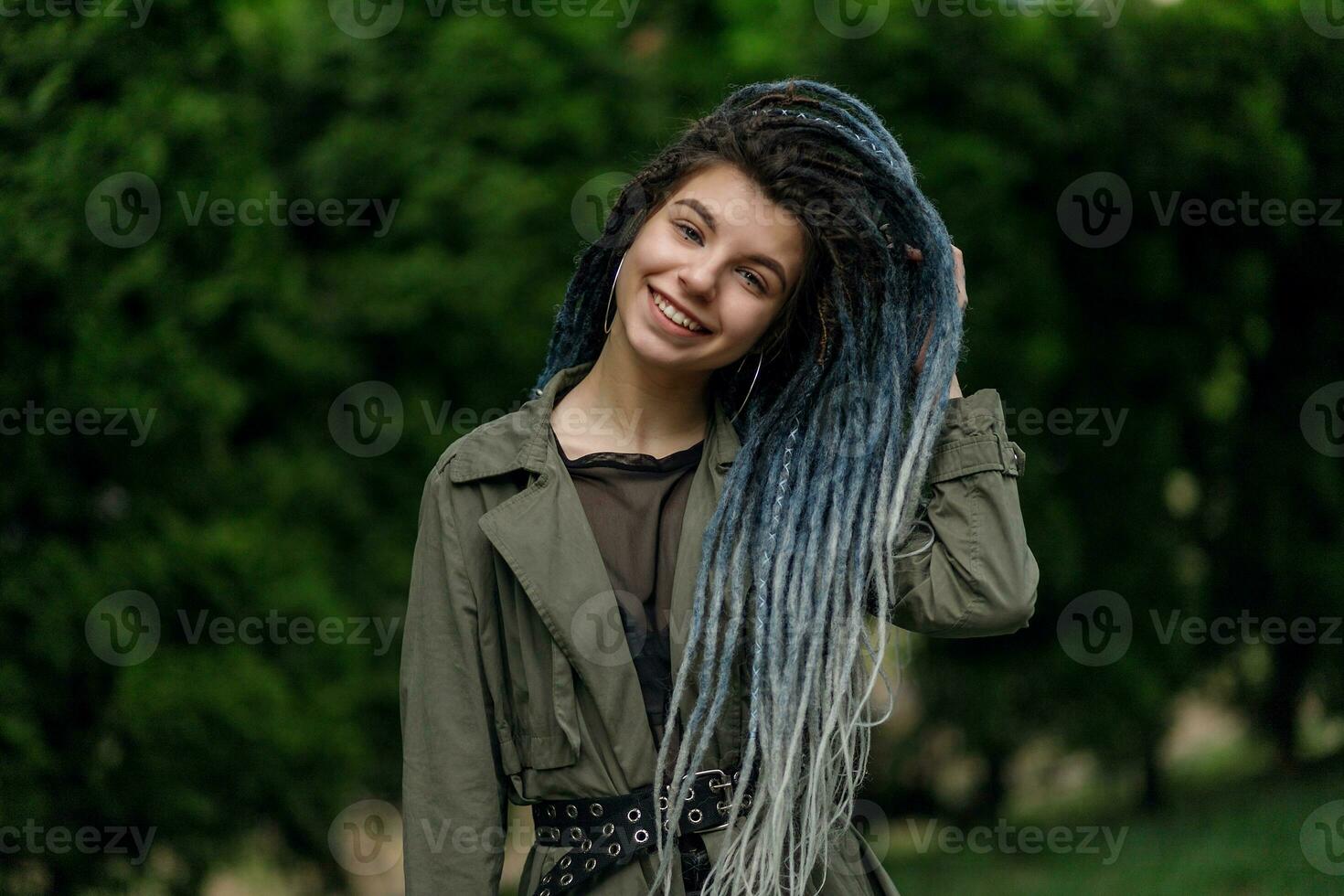 alegre caucasiano menina olhando às a Câmera e sorridente modelo com tranças foto