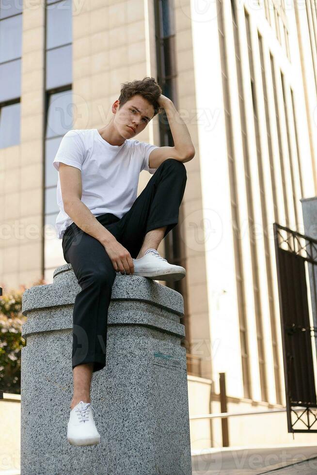 bonito jovem hipster à moda homem dentro branco camisa, Preto calça foto