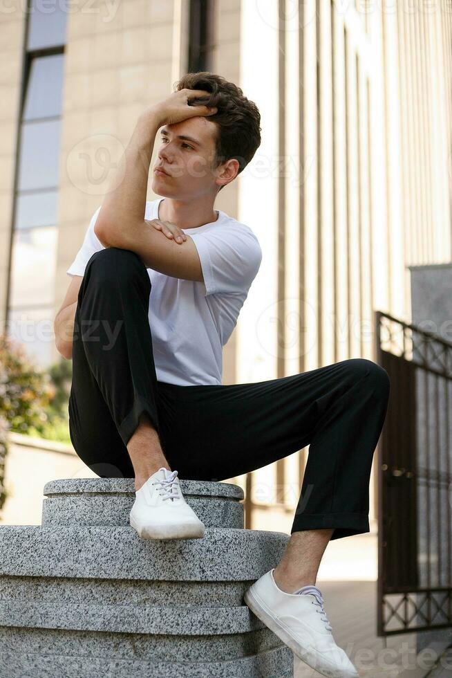 bonito jovem hipster à moda homem dentro branco camisa, Preto calça foto