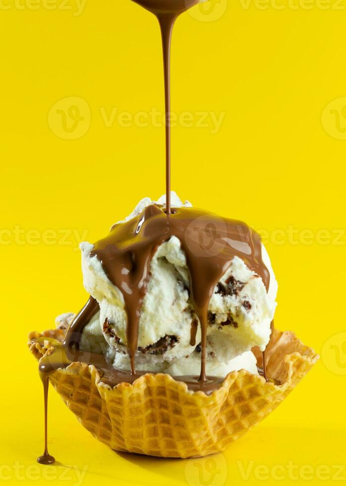 baunilha gelo creme com chocolate cobertura dentro waffle cone em amarelo fundo foto