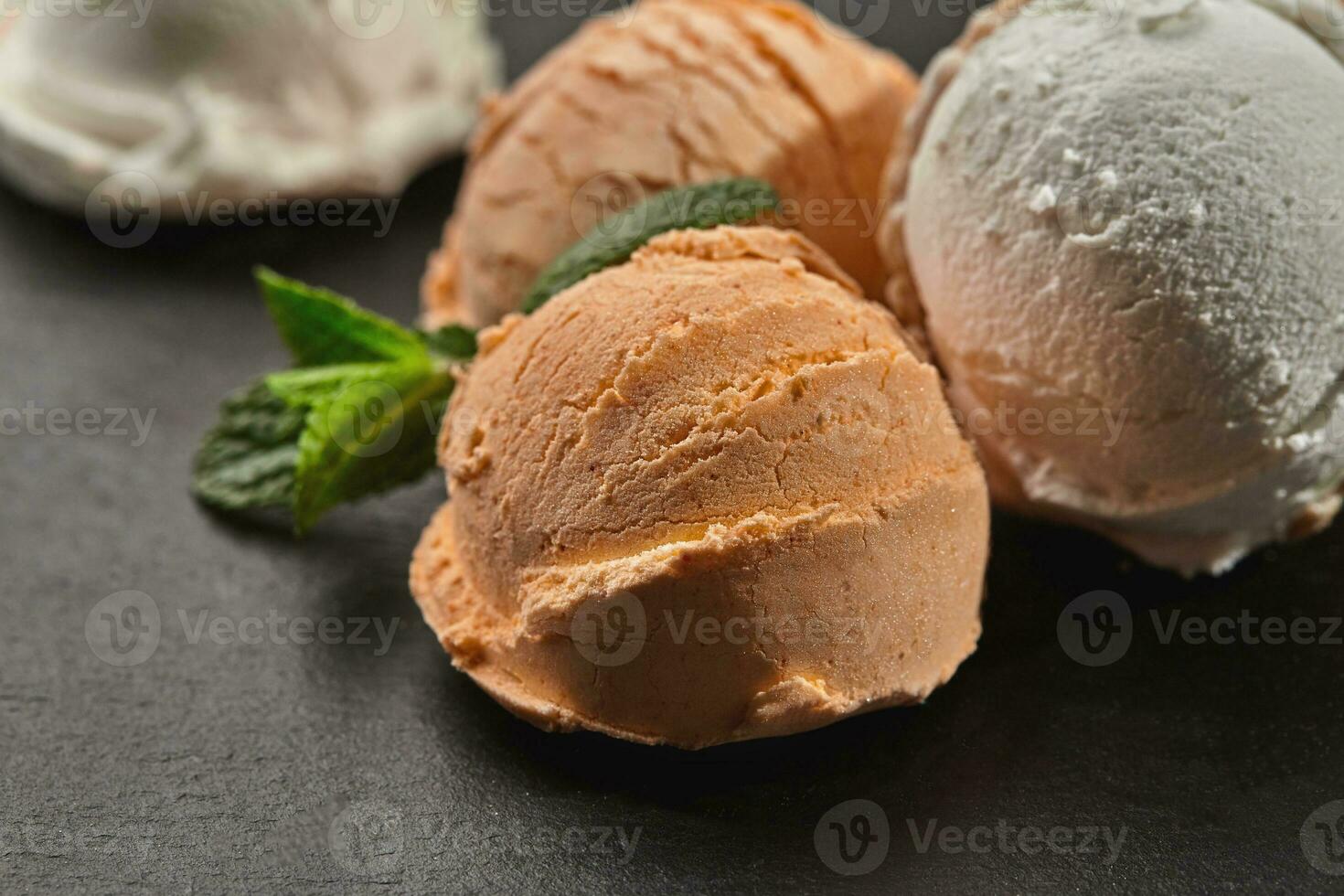 fechar-se tiro do uma cremoso e laranja gelo creme servido em uma Sombrio ardósia, Preto fundo. foto