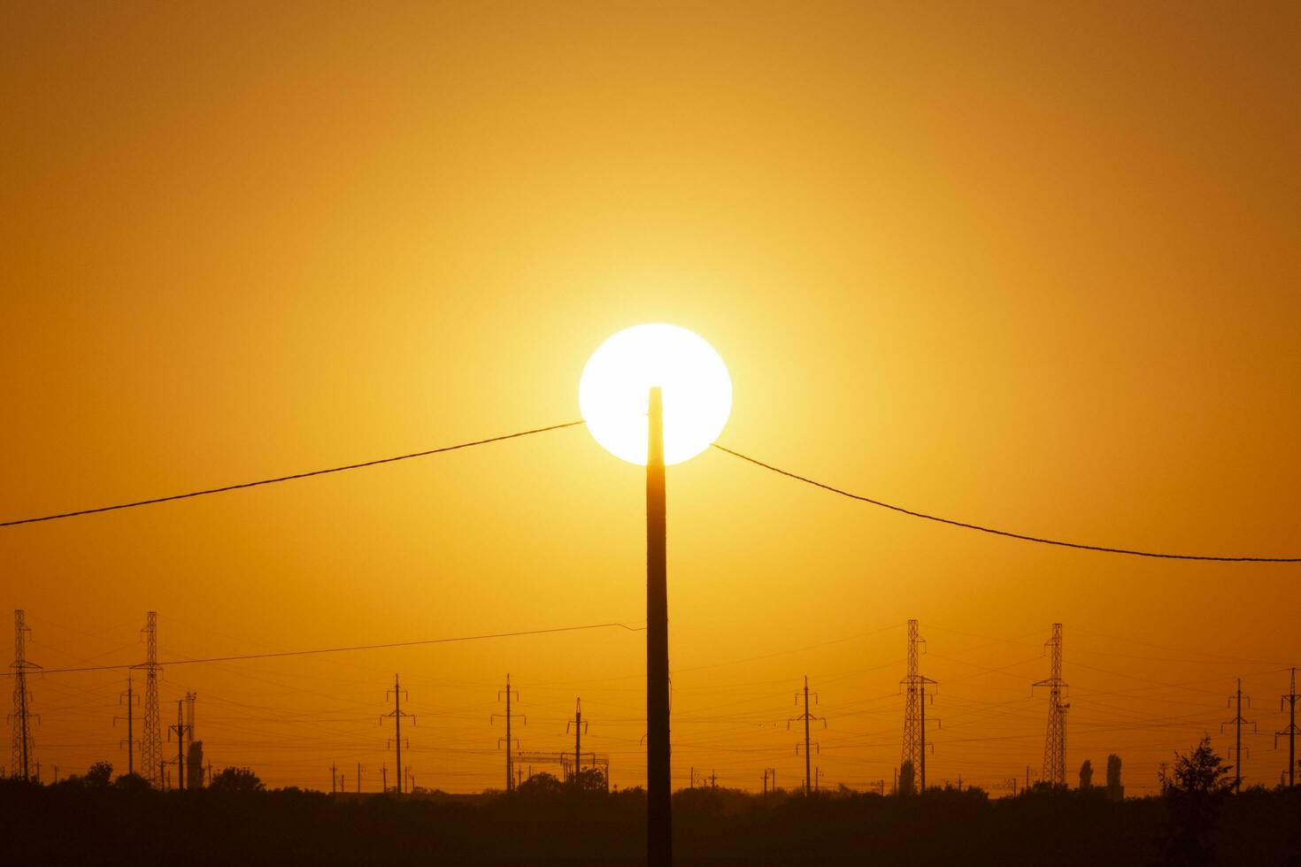 elétrico pólo contra Sol às pôr do sol foto