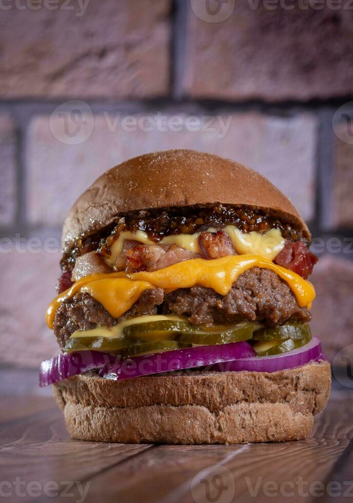 fechar acima do Hamburger em de madeira mesa com tijolo parede dentro fundo foto