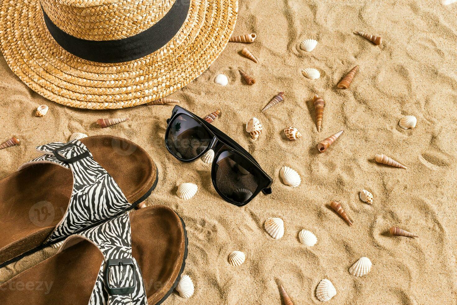 verão roupa de praia, giro fracassos, chapéu, oculos de sol e conchas do mar em areia de praia. foto