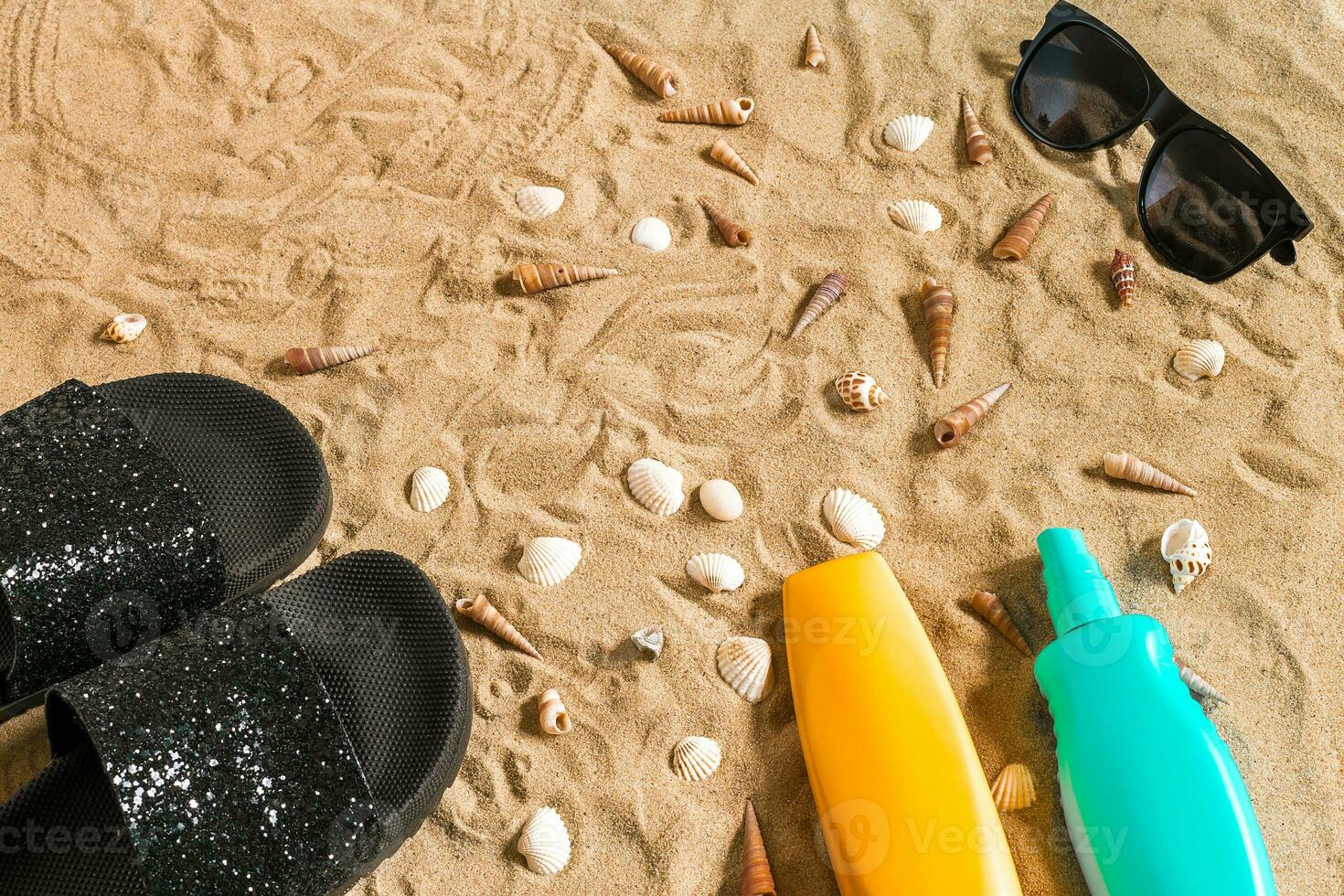 Preto sandálias de dedo e oculos de sol, Concha do mar em areia. com Lugar, colocar para seu texto. topo Visão foto