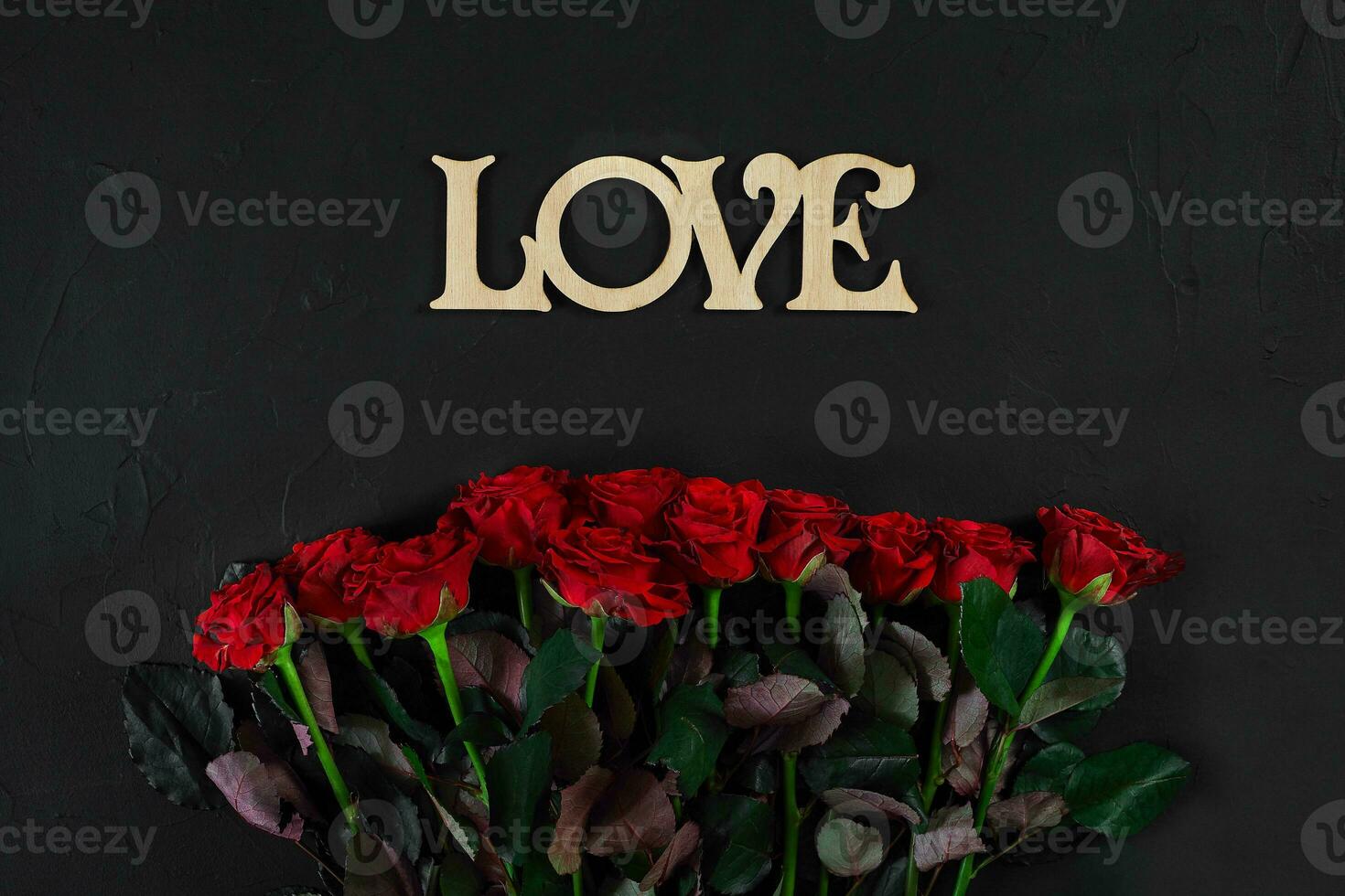 vermelho rosas flores com de madeira palavra amor em Preto fundo com foto