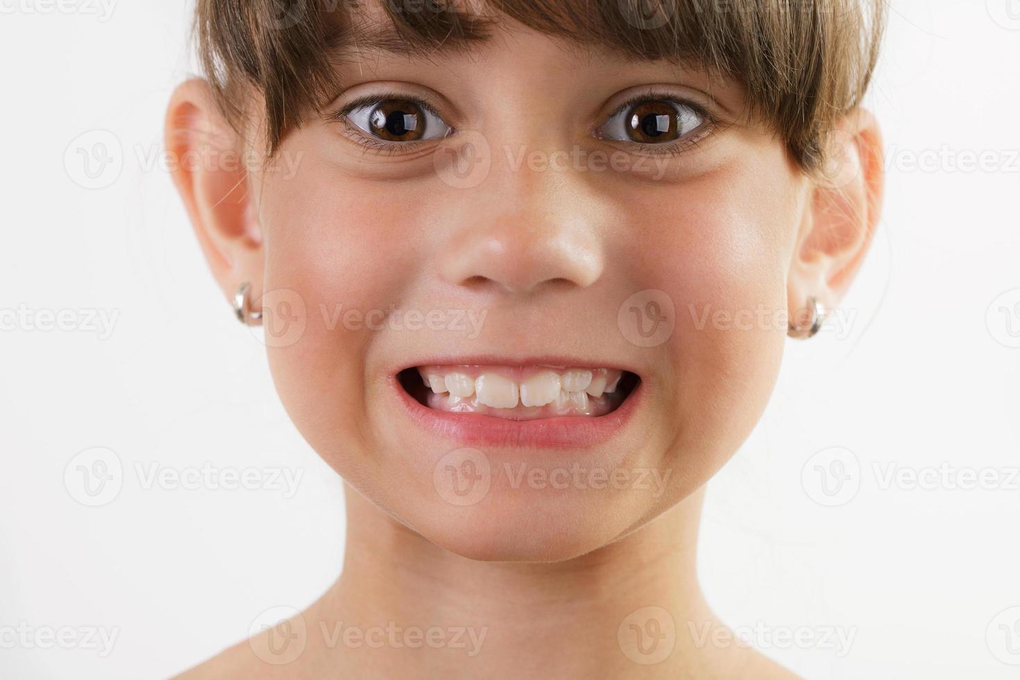 menina alegre e fofa mostra os dentes foto