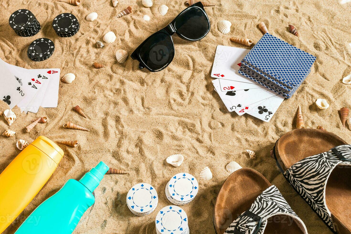 poker de praia. salgadinhos e cartões em a areia. por aí a conchas, oculos de sol e giro fracassos. topo Visão foto