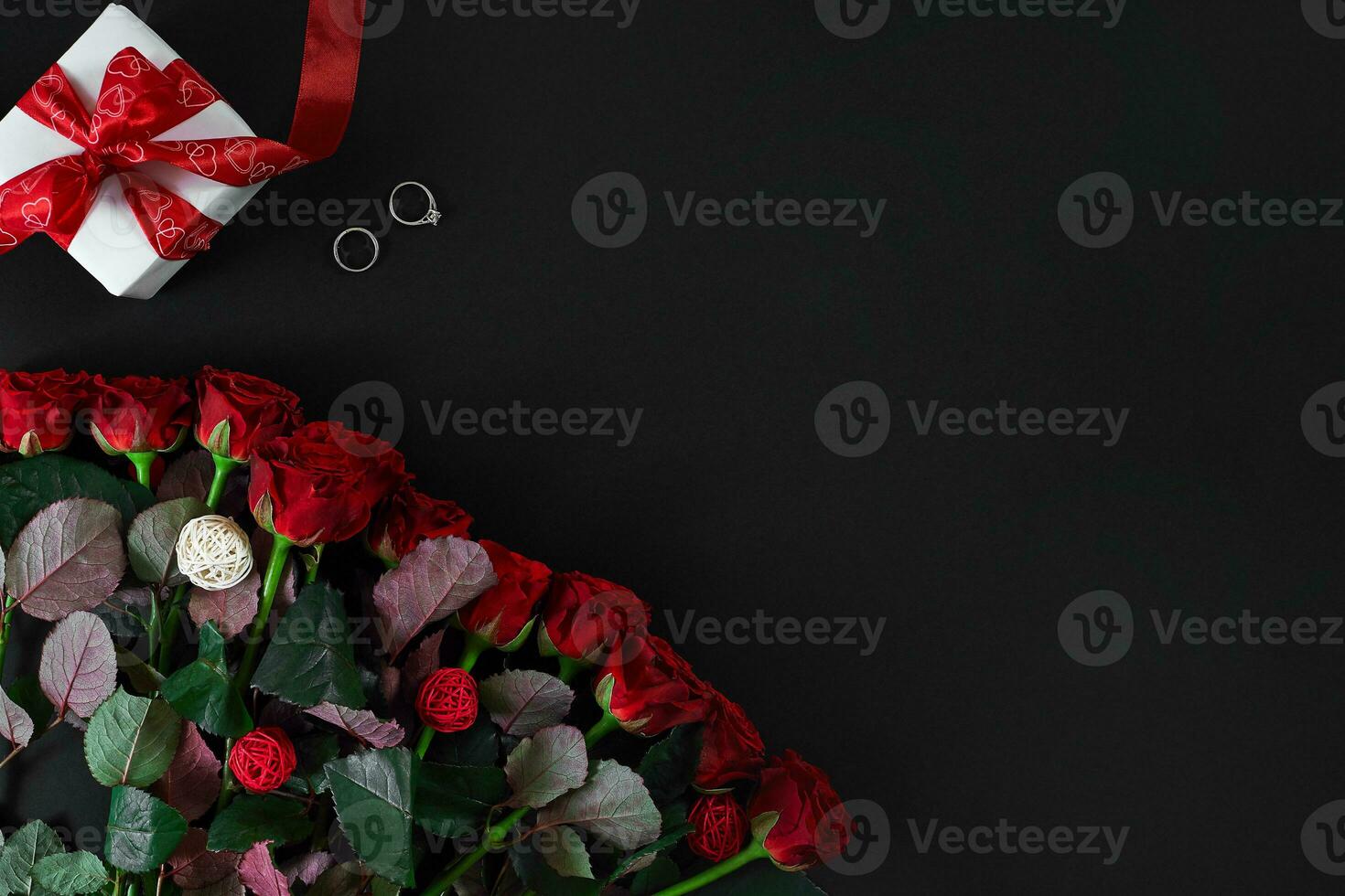 vermelho rosas, anel e presente caixa em Preto fundo foto