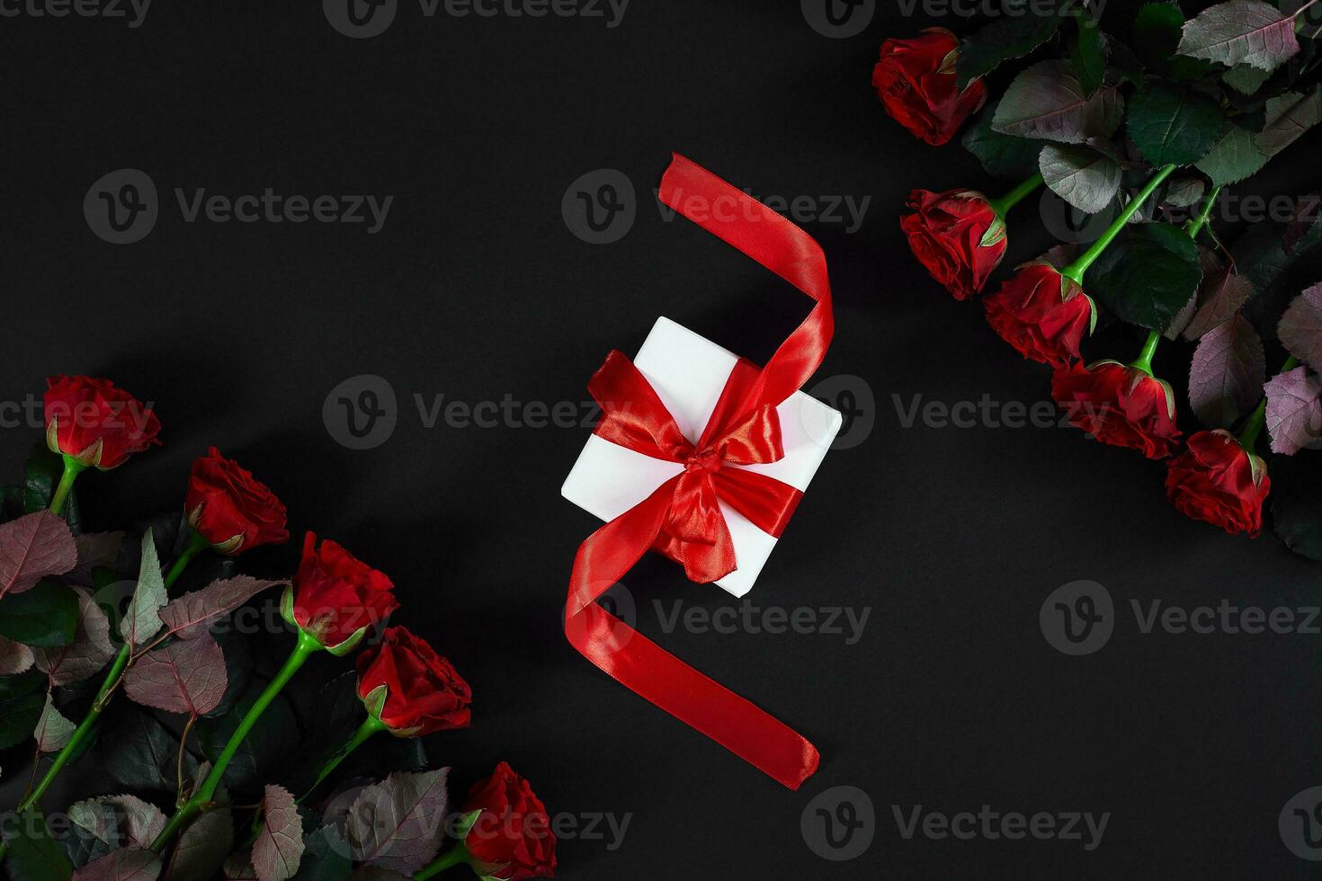 vermelho rosas, anel e presente caixa em Preto fundo foto