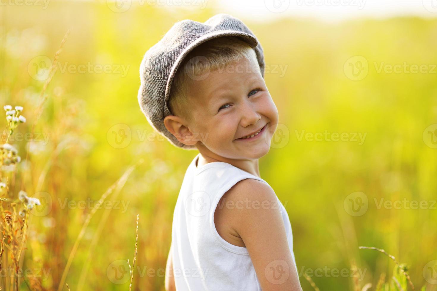 menino feliz e sorridente com um boné cinza foto