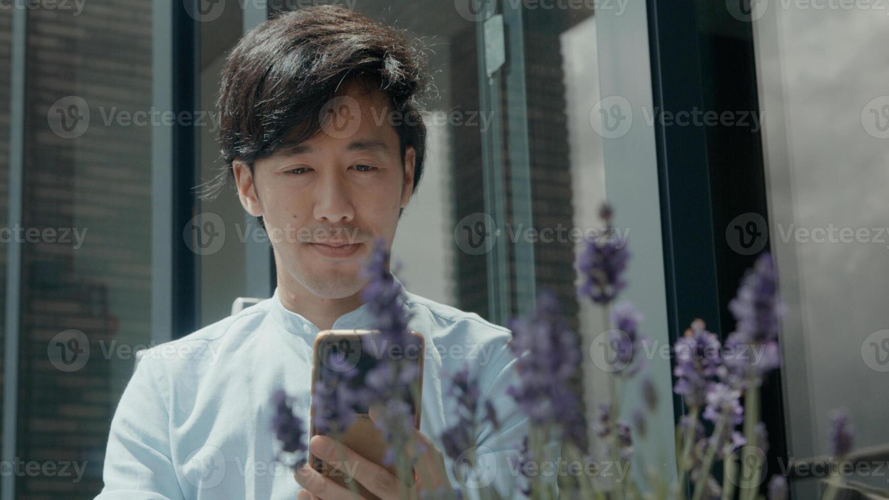homem sentado do lado de fora iniciando videochamada com smartphone foto