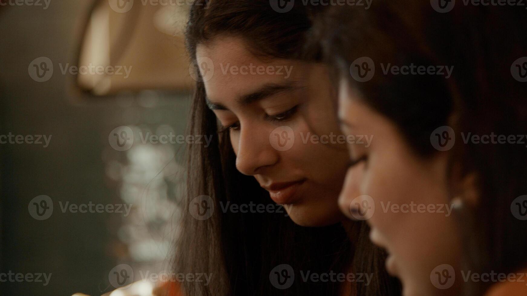 mulher tenta tocar piano e menina senta ao lado dela foto