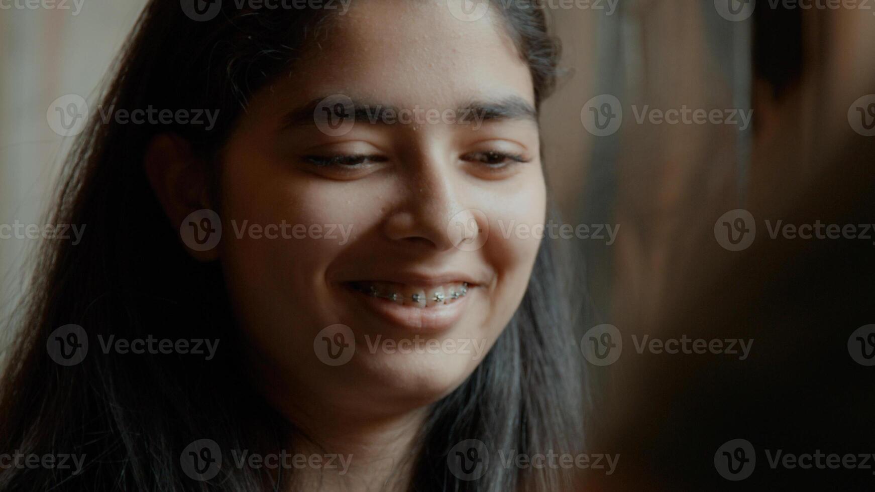 garota assistindo a um tabuleiro de xadrez falando e sorrindo foto